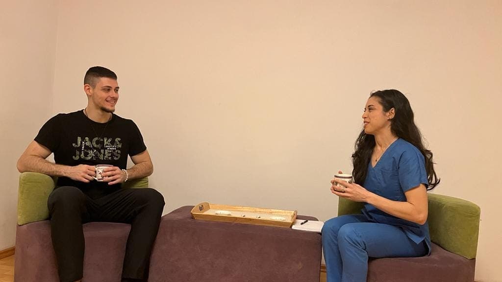 Monica Ganea într-o discuție cu un pacient, servind ceai